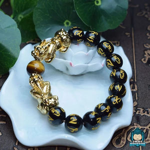 Bracelet-Pixiu-en-véritables-pierres-pièce-unique-artisanale-perles-noires-gravées-de-mantras-et-perle-centrale-oeil-de-tigre-La-Maison-de-Bouddha