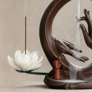 gros plan Porte-encens Main de Bouddha en céramique marron avec fleur de lotus blanche et cascade de fumée