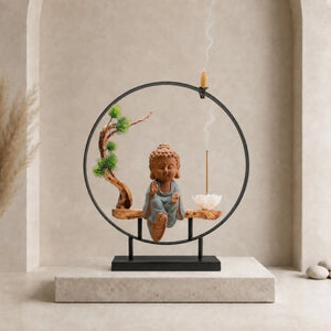 Bouddha brûleur d’encens Bulle Paisible avec tunique bleue, structure circulaire noire, cône à reflux et bâton d’encens