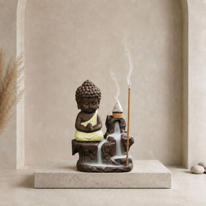 Fontaine brûleur à encens Bouddha en céramique avec robe jaune clair, cône à reflux et support pour bâtonnet.