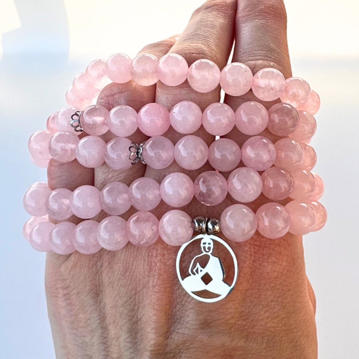 Bracelet mala multi-tours en quartz rose véritable composé de 108 perles et d'un pendentif Bouddha en méditation.