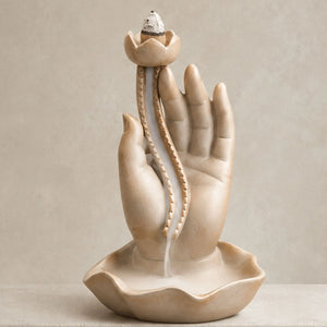 gros plan Porte-encens Main de Bouddha en céramique marron avec fleur de lotus blanche et cascade de fumée