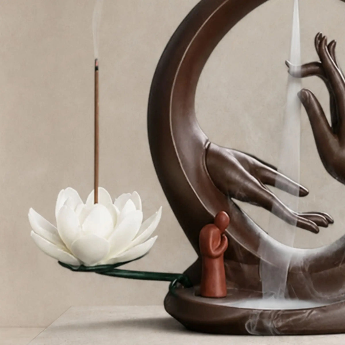gros plan Porte-encens Main de Bouddha en céramique marron avec fleur de lotus blanche et cascade de fumée
