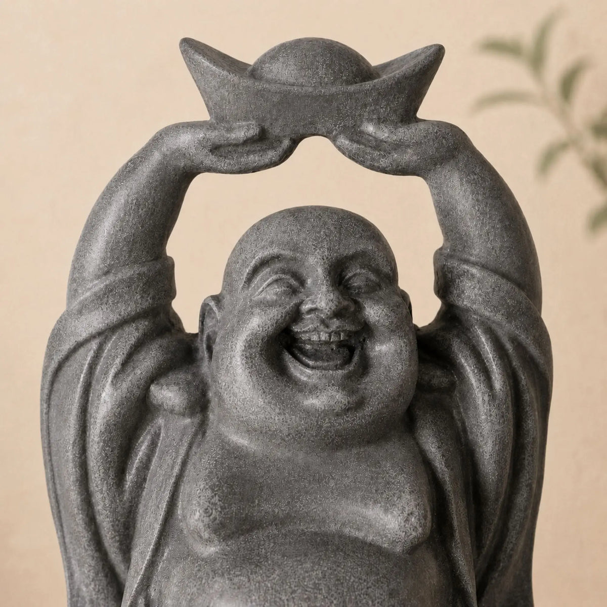 Gros plan sur le visage souriant et le lingot de la statuette Bouddha rieur Budai en résine grise
