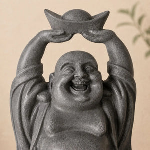 Gros plan sur le visage souriant et le lingot de la statuette Bouddha rieur Budai en résine grise