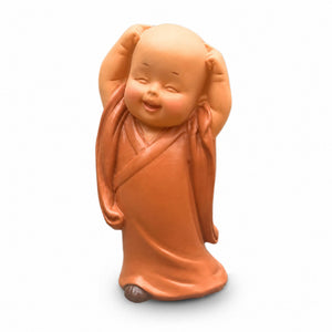 Statuette de petit moine bouddhiste souriant debout les bras levés