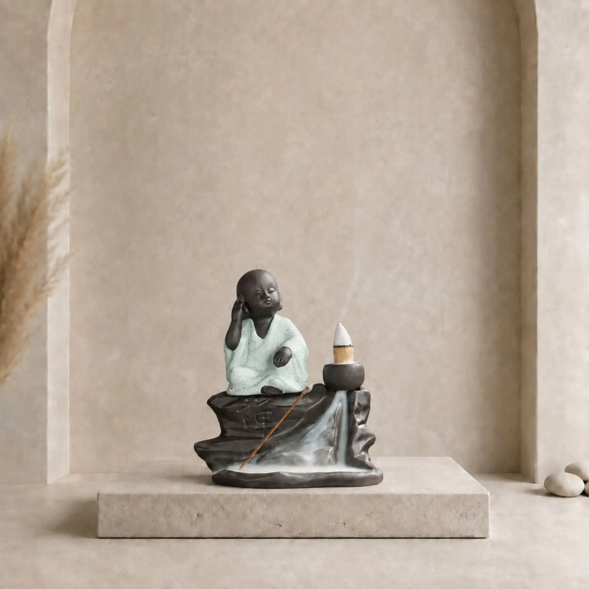 Brûle-encens Bouddha noir en céramique avec petit moine en robe gris clair, cône à reflux et cascade de fumée