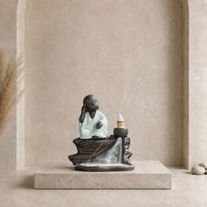 Brûle-encens Bouddha noir en céramique avec petit moine en robe gris clair, cône à reflux et cascade de fumée