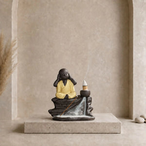 Brûle-encens Bouddha noir en céramique avec petit moine en robe jaune, cône à reflux et cascade de fumée