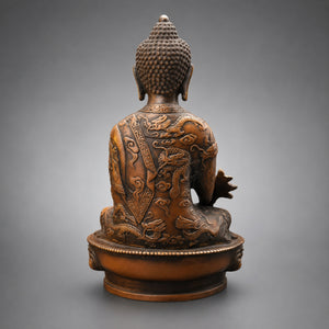 Vue de dos de la statuette Bouddha assis en cuivre et laiton avec motifs de dragons