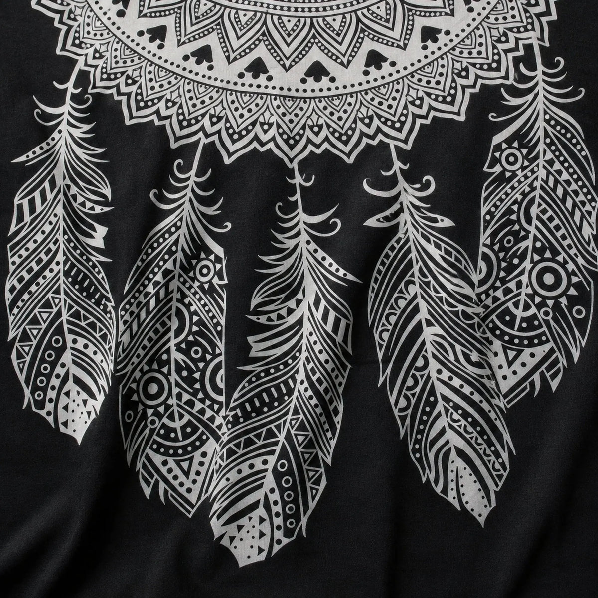 Gros plan sur les plumes décoratives de la tenture attrape-rêves mandala noir et blanc en coton