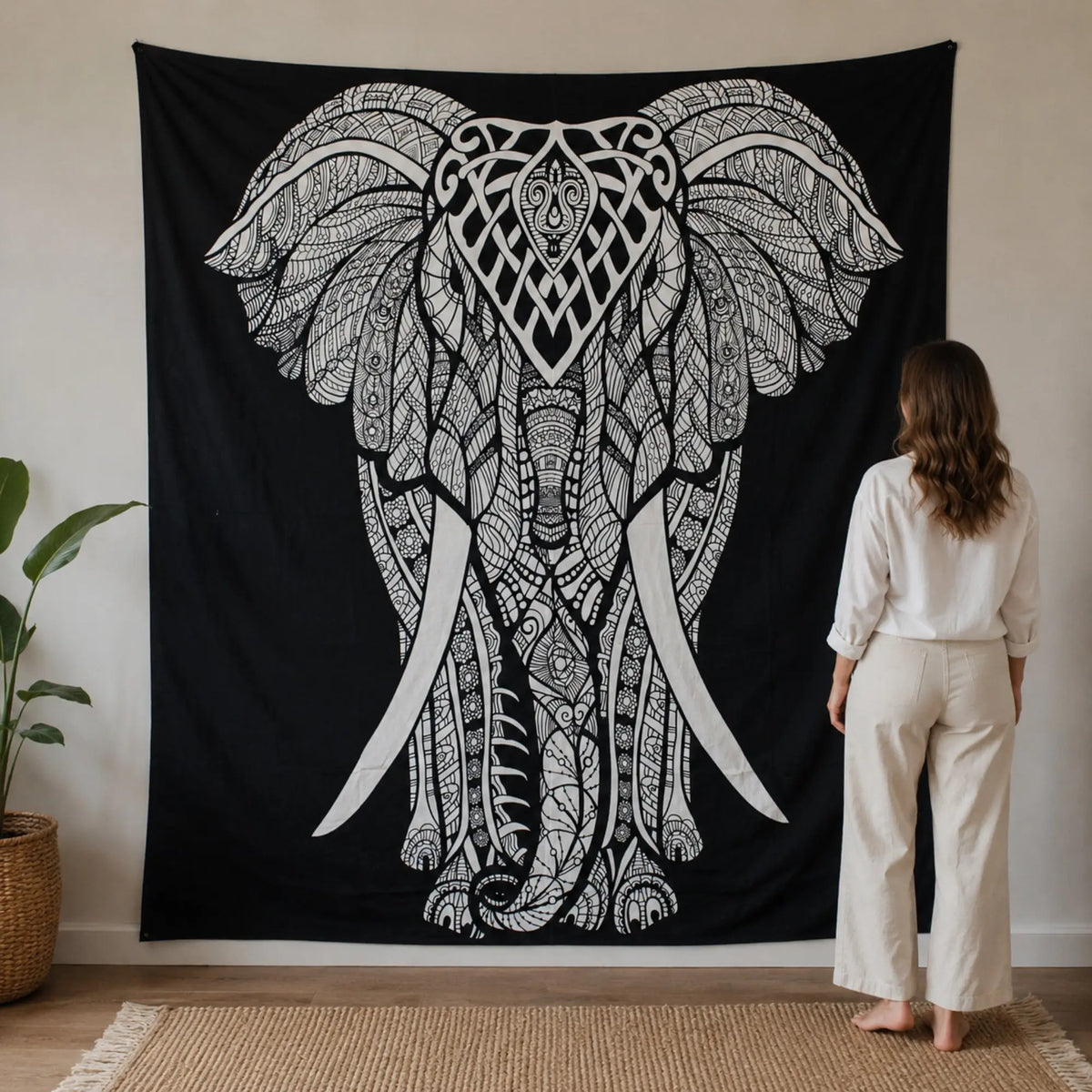 Grande tenture éléphant noir et blanc présentée à l’échelle avec une personne