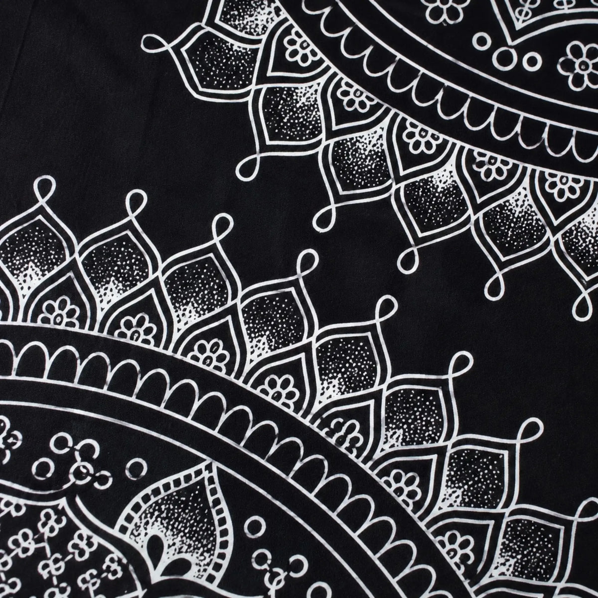 Gros plan sur l’impression noire et blanche et les motifs de la tenture mandala en coton
