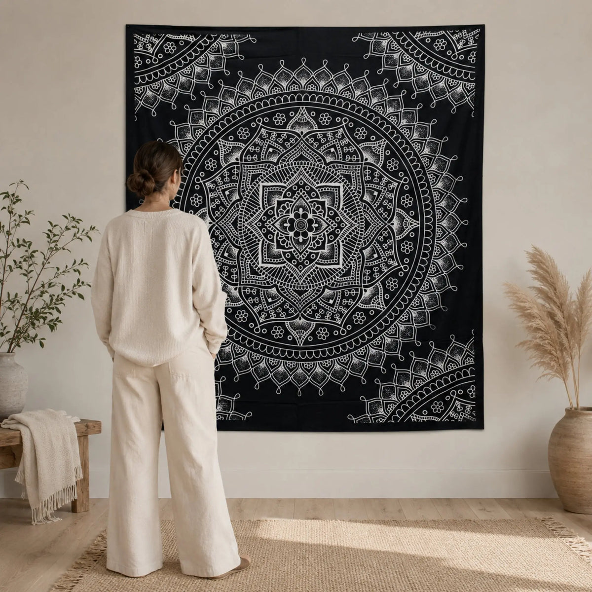 Grande tenture mandala fleur de lotus noir et blanc présentée à l’échelle avec une personne