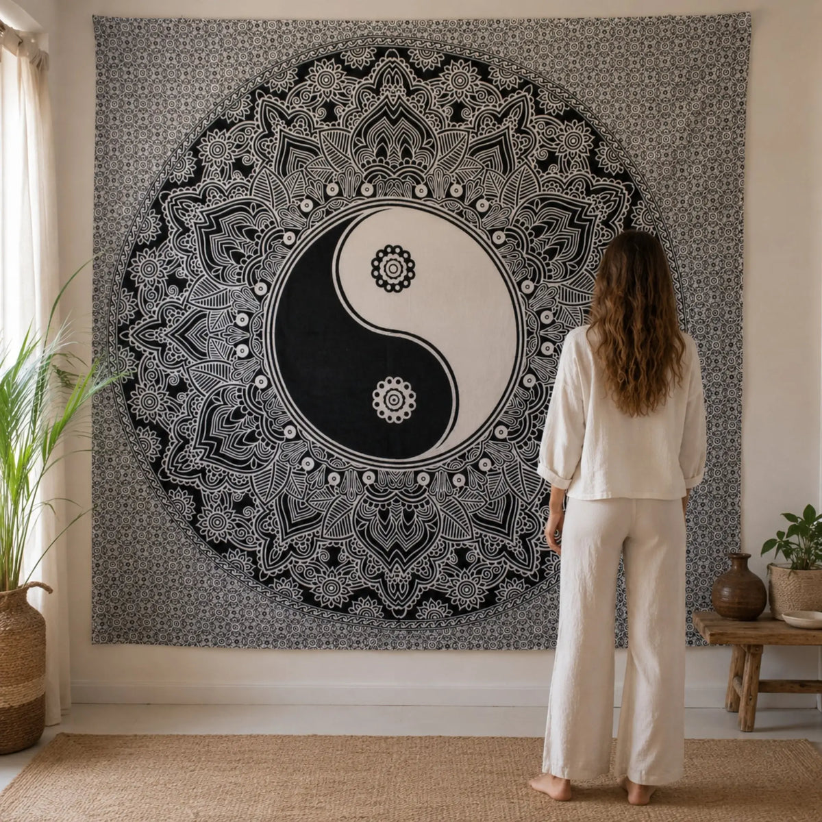 Grande tenture Yin Yang mandala noir et blanc présentée à l’échelle avec une personne
